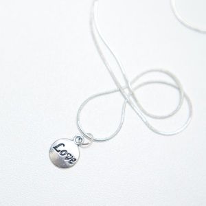 22 inch silver necklace with charm that says love